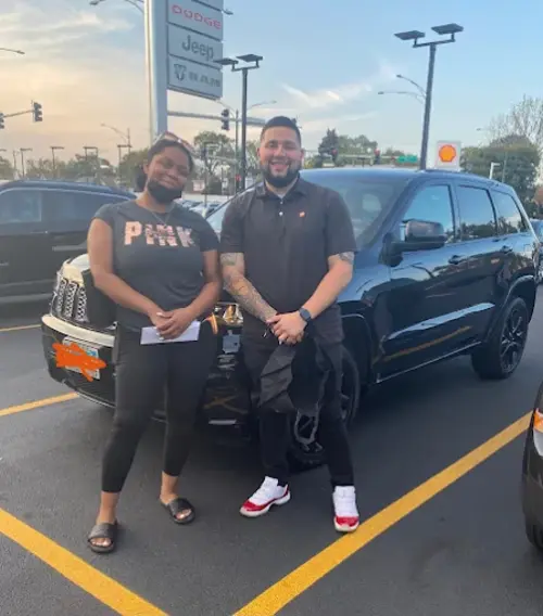Two customers beside the Jeep Grand Cherokee they collected at a Reineke dealership