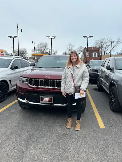 A customer standing in front of her Jeep Grand Cherokee