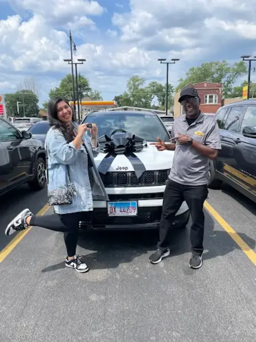 A customer with a new vehicle and a member of the Reineke team