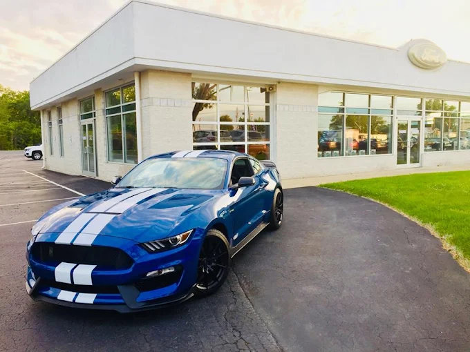 A blue Ford Mustang Shelby outside a Reineke showroom