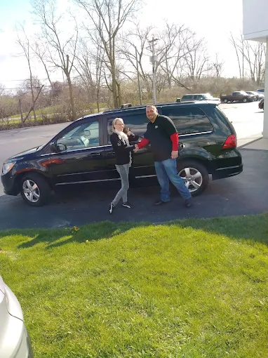 Two people beside a black Honda Odyssey