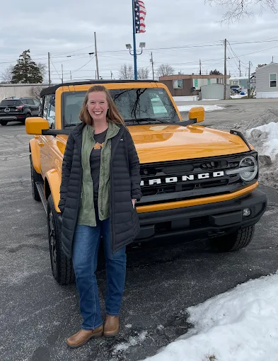 A customer beside an orange Ford Bronco